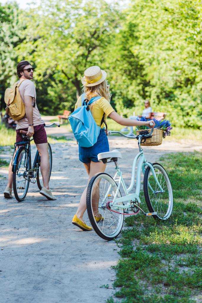 夏の日の公園でレトロな自転車とカップルの背面します。 - 写真・画像