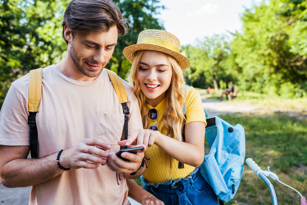 портрет улыбающейся пары с помощью смартфона в парке в летний день
 - Фото, изображение