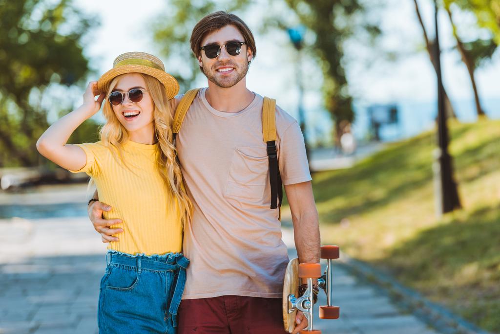 retrato de pareja sonriente con longboard en el día de verano
 - Foto, Imagen