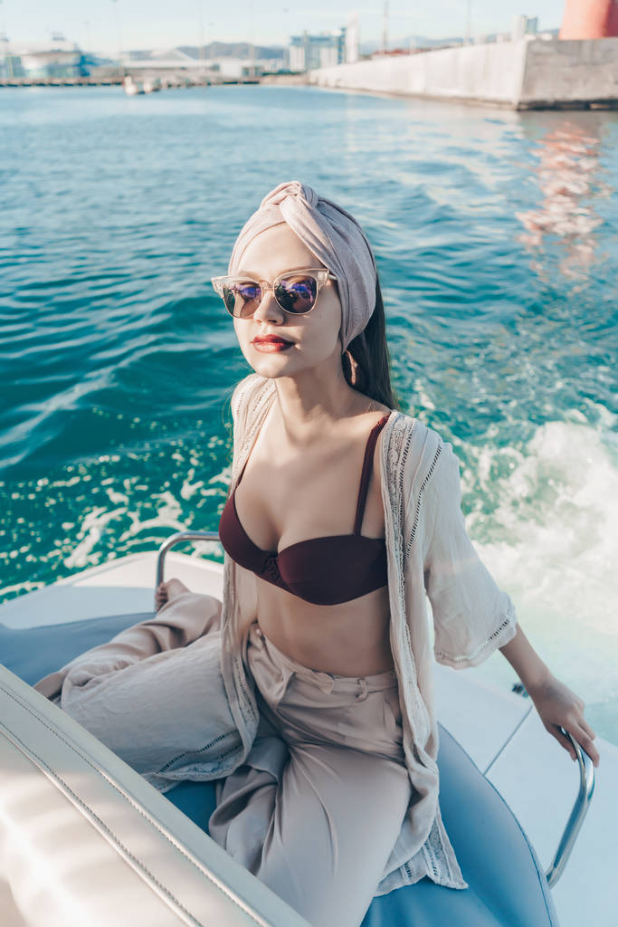 eine reiche schöne Frau mit Sonnenbrille genießt einen Urlaub auf ihrer Jacht, segelt in der Karibik - Foto, Bild