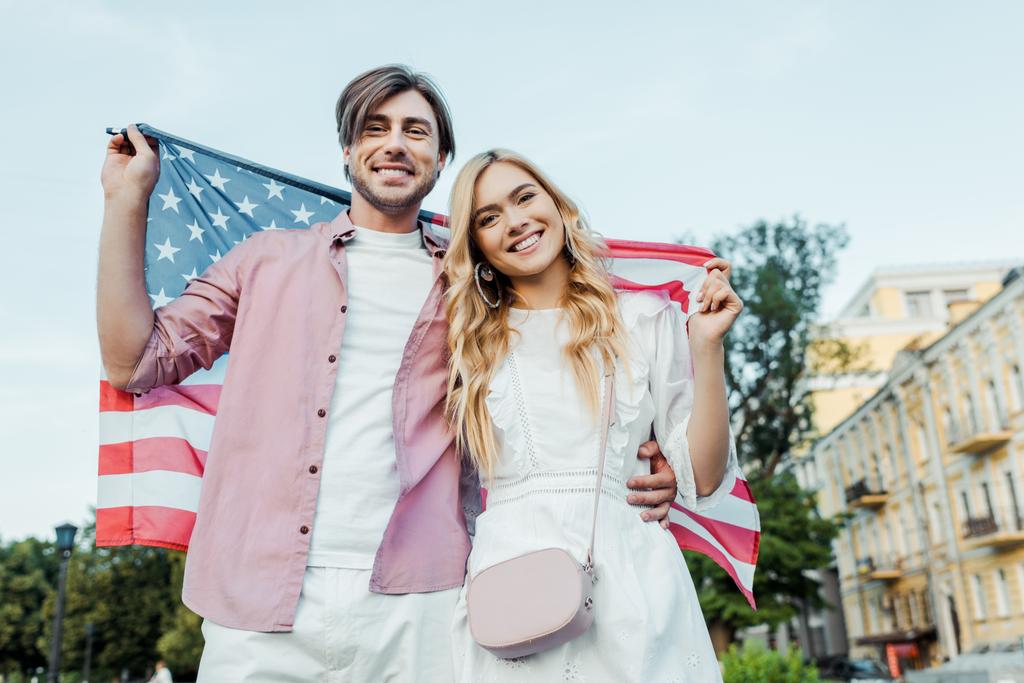 щасливі молодої пари, що тримає американський прапор в руках, День незалежності Південної Америки концепції - Фото, зображення