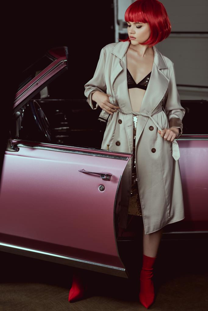 elegáns lány, a melltartó és viharkabátban áll közelében retro autó - Fotó, kép