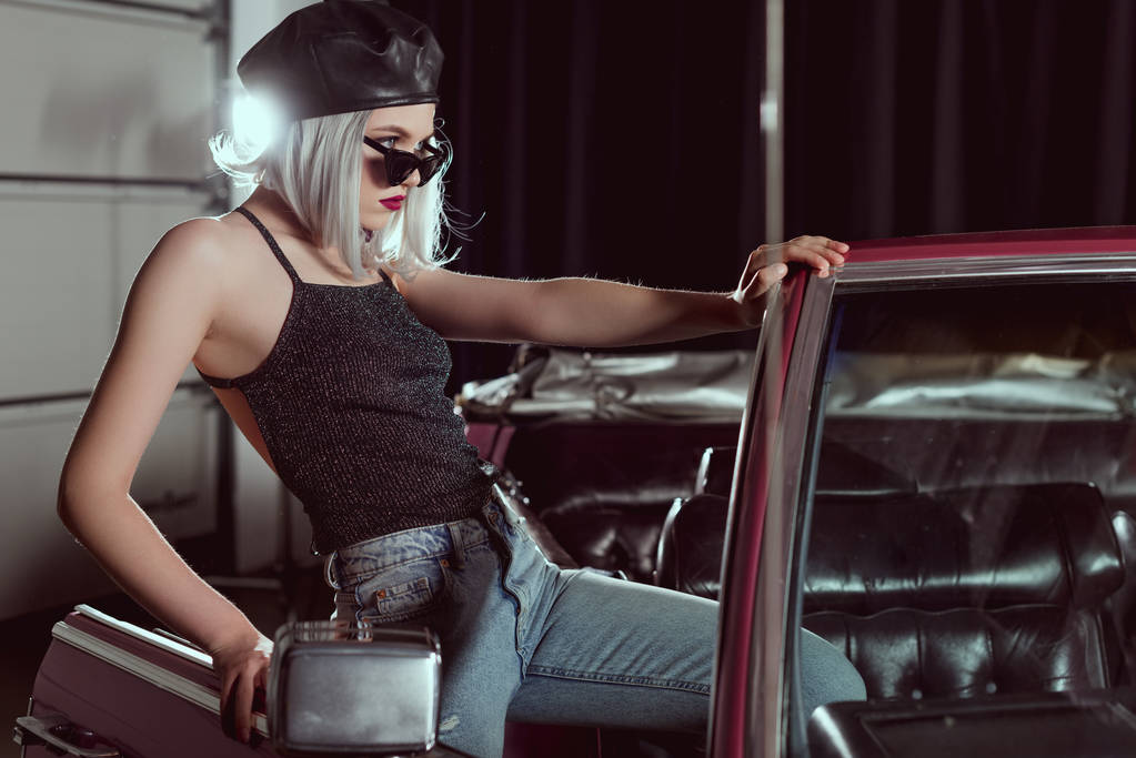 Şık sarışın kız siyah bere ve klasik otomobil açarak ve uzak arayarak güneş gözlüğü - Fotoğraf, Görsel