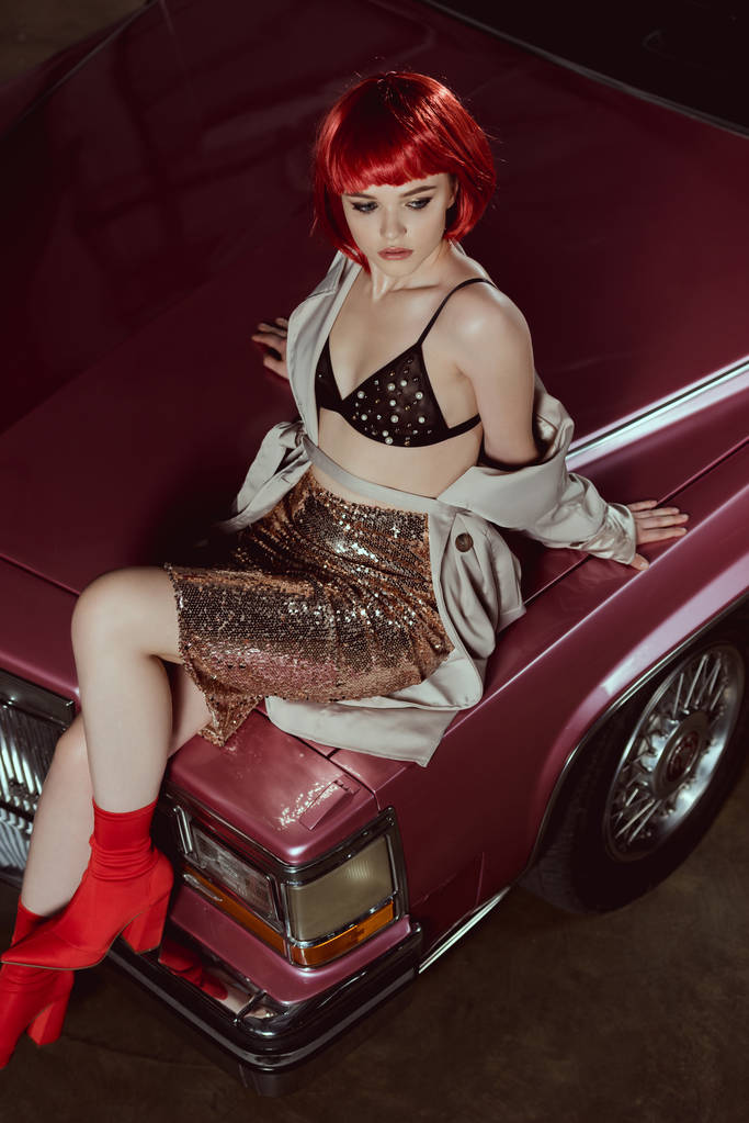 high angle view of beautiful stylish girl in red wig sitting on classic car - Photo, Image
