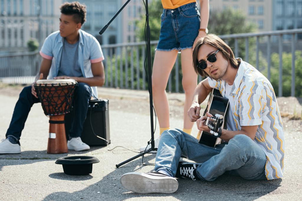 Jóvenes multirraciales realizando improvisados conciertos en la calle
 - Foto, Imagen