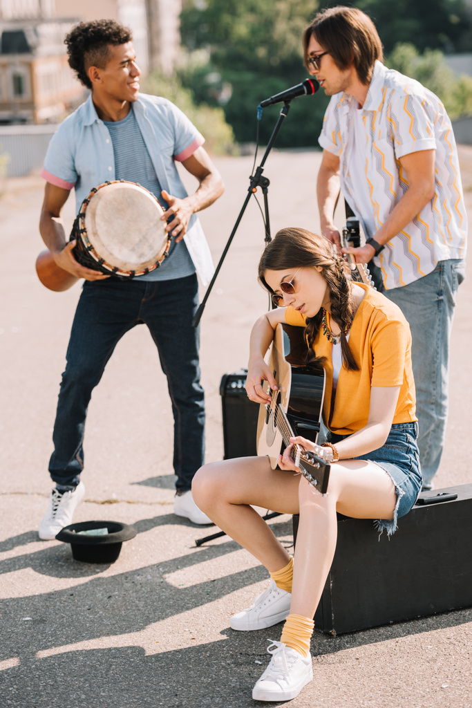 Молоді та щасливі багаторасові чоловічі та жіночі вуличні музиканти в місті
 - Фото, зображення