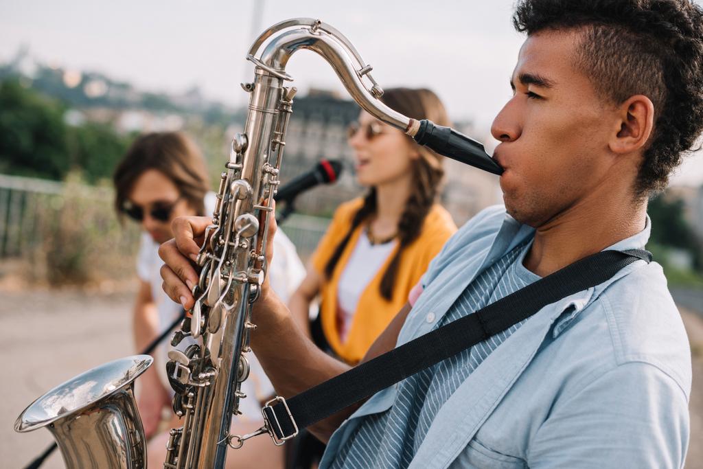 Giovani felici uomini e donne che suonano musica in strada
 - Foto, immagini