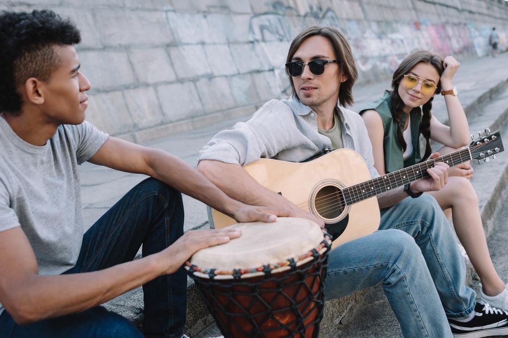 Jóvenes multiraciales realizando concierto musical en la calle
 - Foto, Imagen
