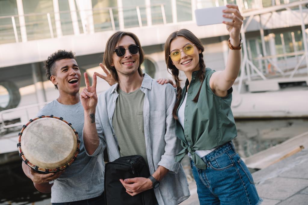 Team van jonge musici met instrumenten selfie nemen in stedelijke omgeving - Foto, afbeelding