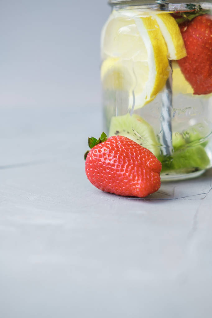 Hedelmävesi sitruunalla ja mansikoilla lasipurkissa
 - Valokuva, kuva