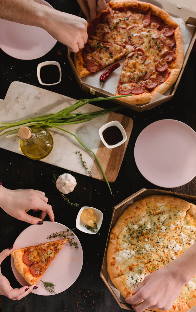 Pizza em mesa de madeira com pratos brilhantes para festa. Foto de comida tonificante rústica escura. Imagem de vista superior
. - Foto, Imagem