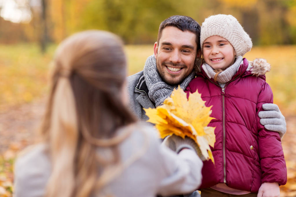 familia feliz con hojas de arce en el parque de otoño
 - Foto, Imagen