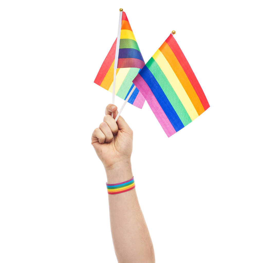 χέρι με γκέι σημαίες ουράνιο τόξο υπερηφάνεια και βραχιολάκι - Φωτογραφία, εικόνα