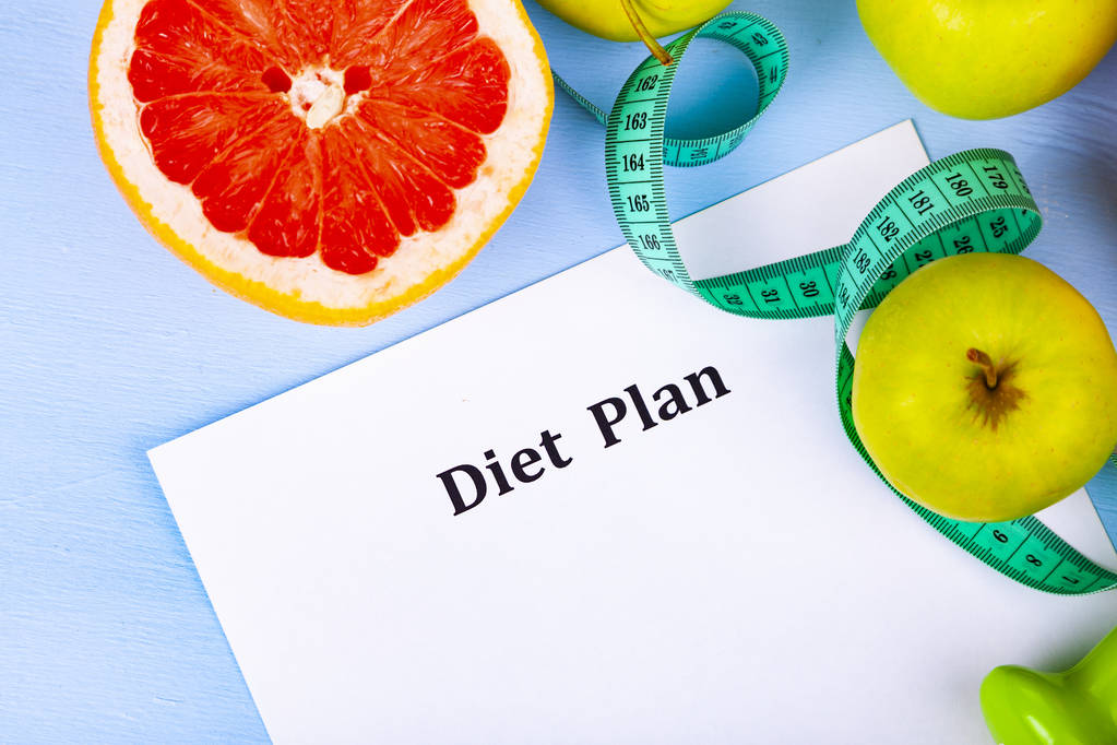 食品と青い木製の背景に食事療法の計画用紙 1 枚。ダイエットや健康的なライフ スタイルのコンセプト. - 写真・画像