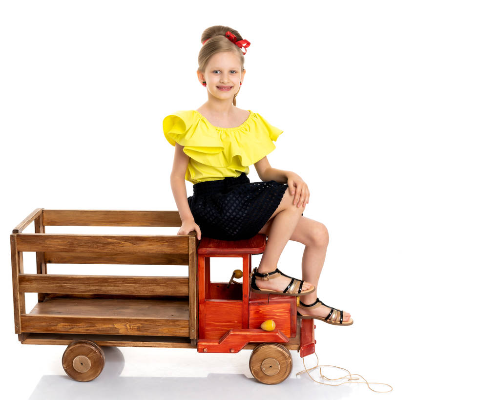 Kislány játszik egy fából készült autó. - Fotó, kép