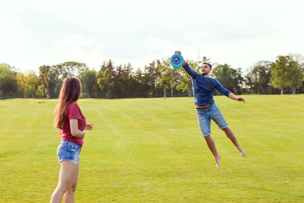 couple in love playing frisbee in the park, the concept of a healthy lifestyle. - Photo, Image