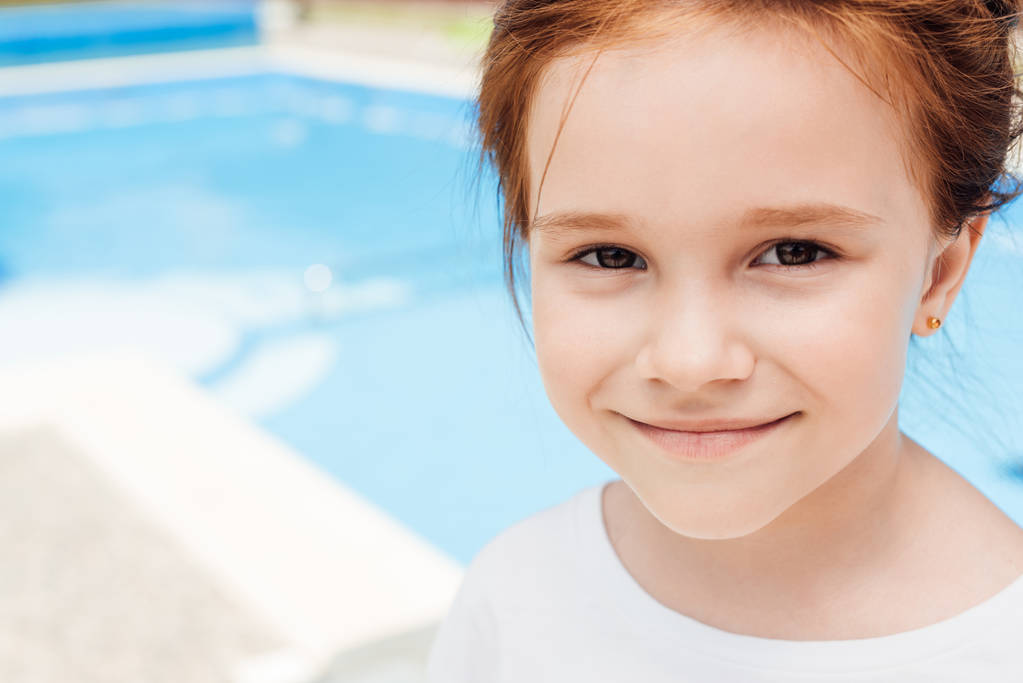 retrato de primer plano de un niño feliz frente a la piscina
 - Foto, imagen