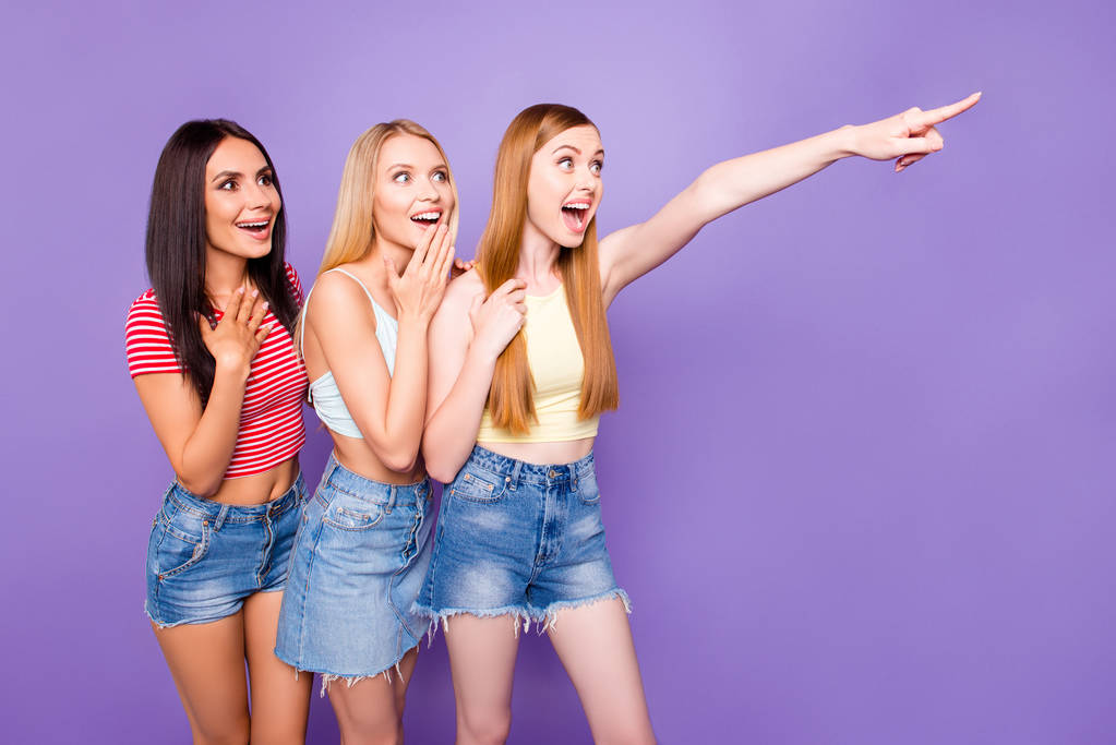 Концепция рекламы. Портрет удивленных удивленных девушек в повседневных нарядах, смотрящих с невероятным выражением жеста указательным пальцем, изолированным на ярком фиолетовом фоне
 - Фото, изображение