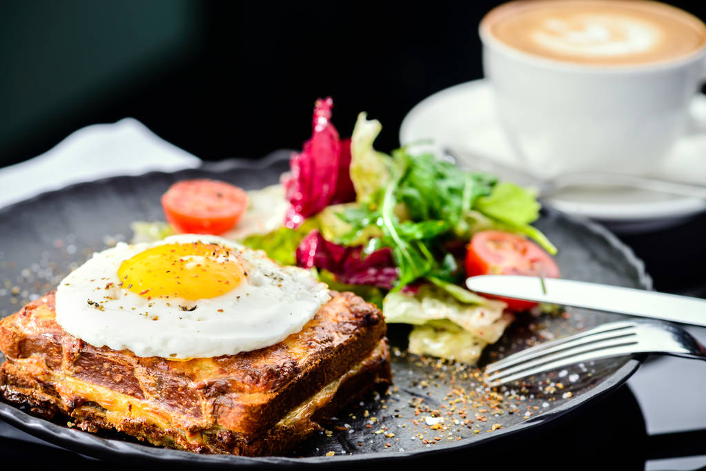 Блюдо с тостами с жареными яйцами и салат с помидорами и летт
 - Фото, изображение