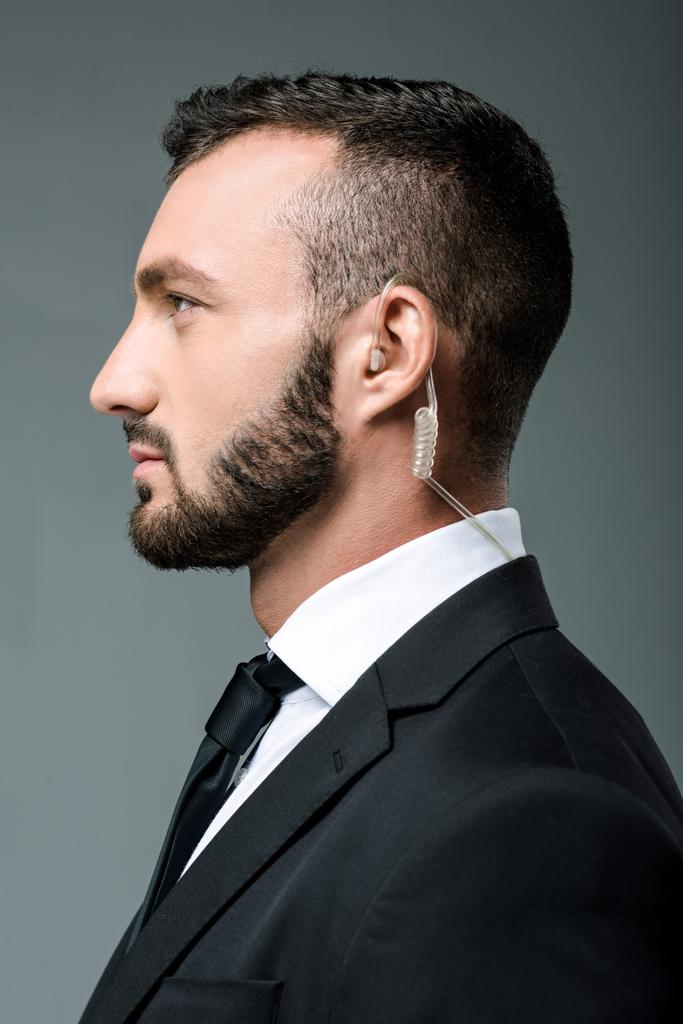 profile of handsome security guard with security earpiece isolated on grey - Photo, Image
