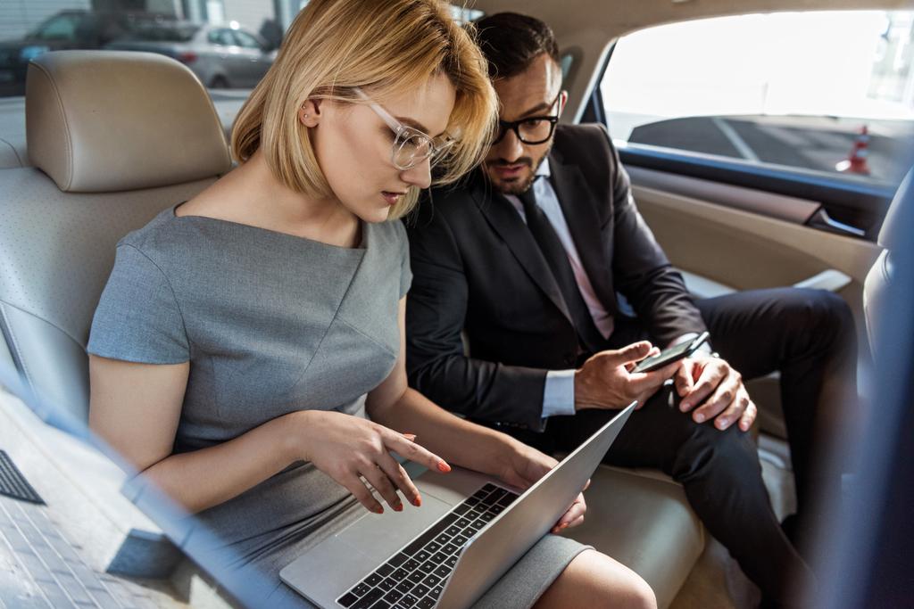 zakenman assistent werken in auto met laptop - Foto, afbeelding
