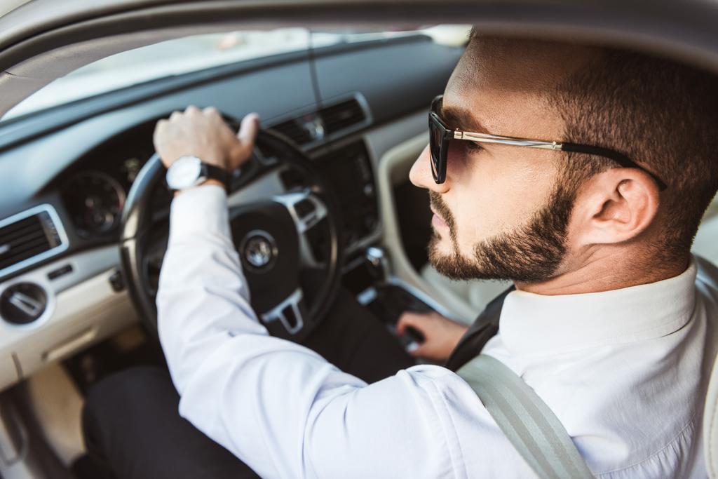 knappe chauffeur in zonnebril auto rijden - Foto, afbeelding