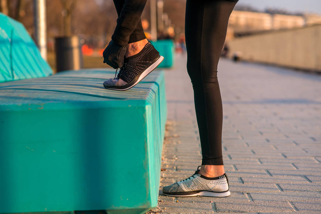 Lähikuva katsoa urheilullinen nainen sitoo hänen kengännauhat
 - Valokuva, kuva