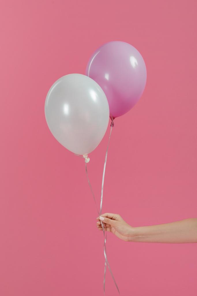 Bijgesneden beeld van vrouw met twee ballonnen geïsoleerd op roze - Foto, afbeelding