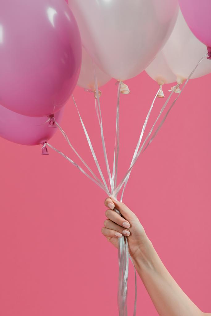 Γυναικείο χέρι κρατά αερόστατα απομονώνονται σε ροζ - Φωτογραφία, εικόνα