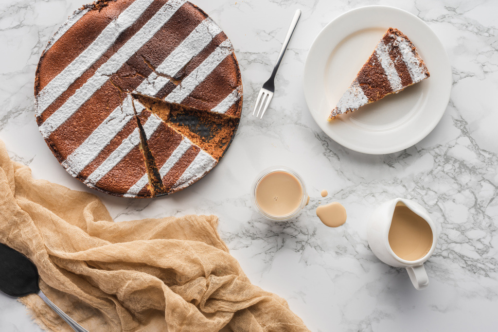 το Top view νόστιμο σπιτικό κέικ με ζάχαρη σε σκόνη και ζεστή σοκολάτα σε μαρμάρινη επιφάνεια - Φωτογραφία, εικόνα