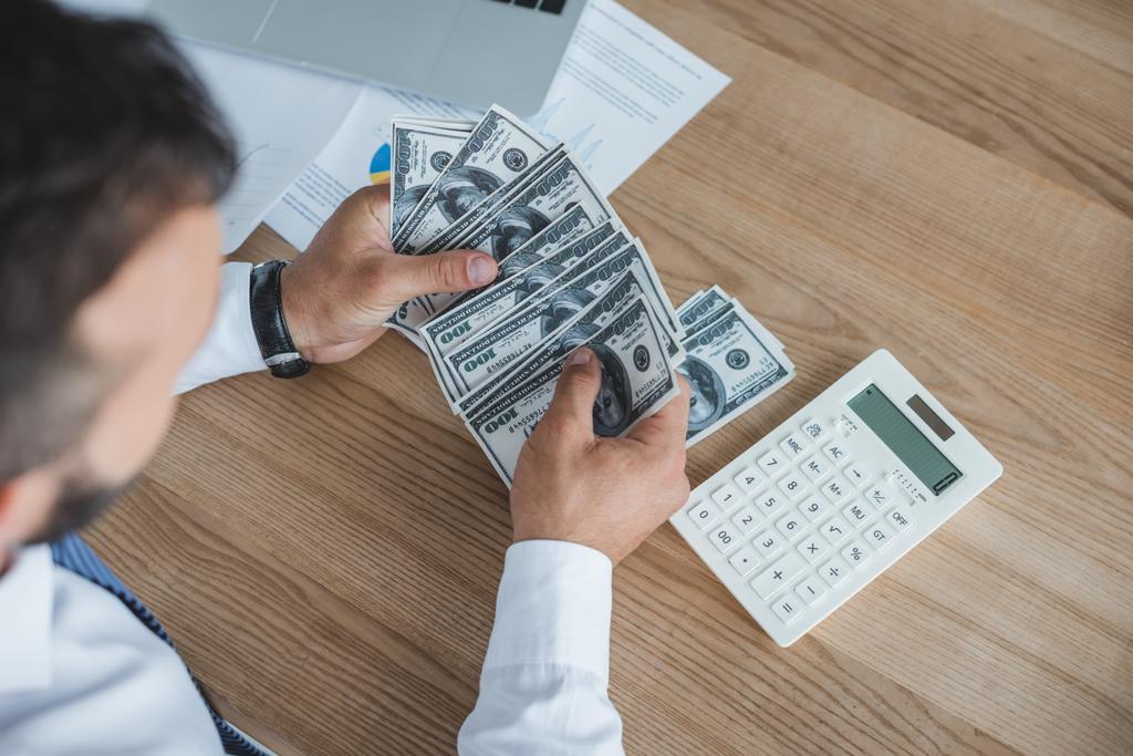 imagem cortada do financiador contando dinheiro com calculadora no escritório
 - Foto, Imagem