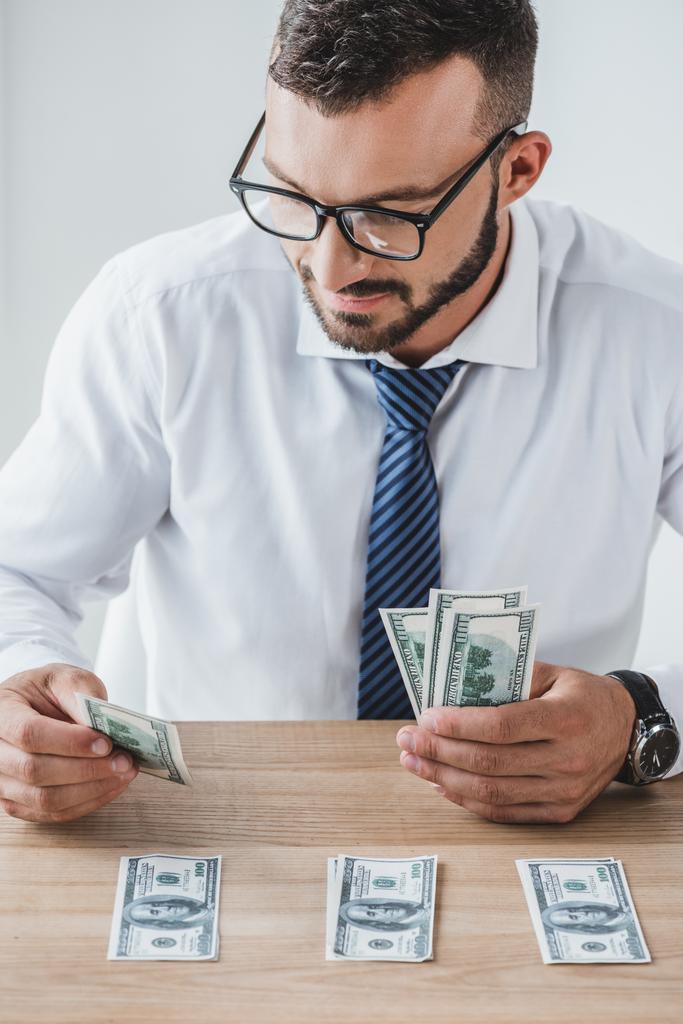 consultor de negócios bonito em óculos contando notas de dólar na mesa no escritório
 - Foto, Imagem