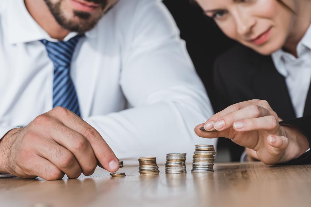 cropped image of business advisers stacking coins on table in office - Photo, Image