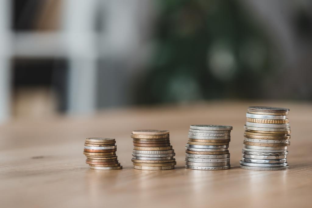Stapel von Münzen auf hölzerner Tischplatte im Finanzamt - Foto, Bild