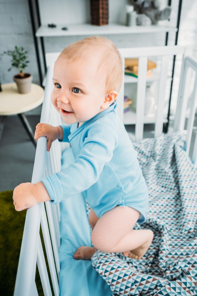 幸せな赤ちゃんのベビーベッドに立ってハイアングル - 写真・画像