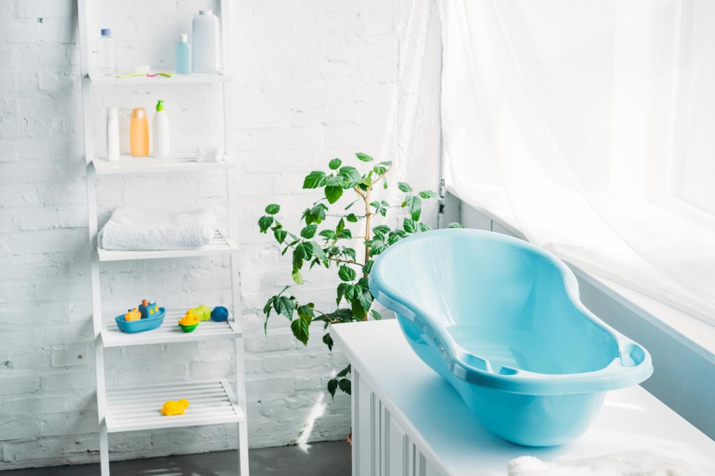 bañera de plástico para niños en el stand en la habitación moderna blanca
 - Foto, imagen