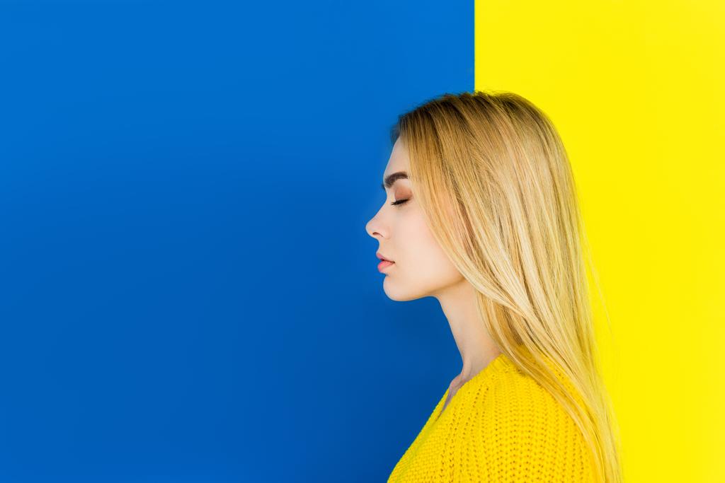Portrait de fille aux yeux fermés portant des vêtements jaunes isolés sur fond bleu et jaune
 - Photo, image