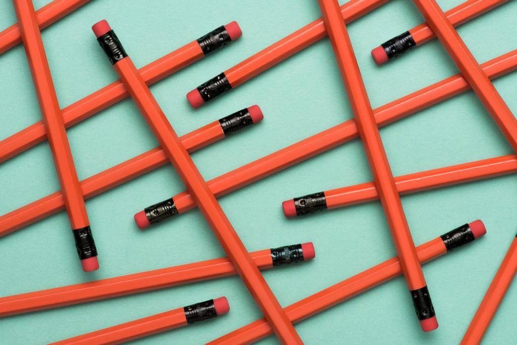 вид зверху розставлені червоні графітові олівці з естакадами на зеленому
 - Фото, зображення