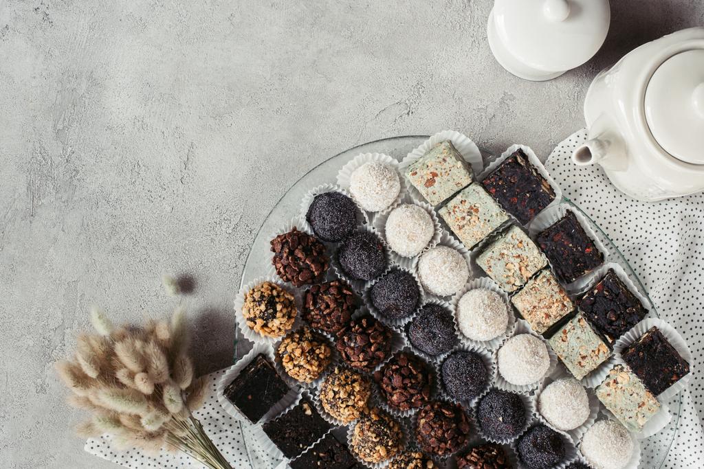 çeşitli tatlı tatlılar plaka, Çaydanlık ve keten gri yüzeyi düz lay - Fotoğraf, Görsel