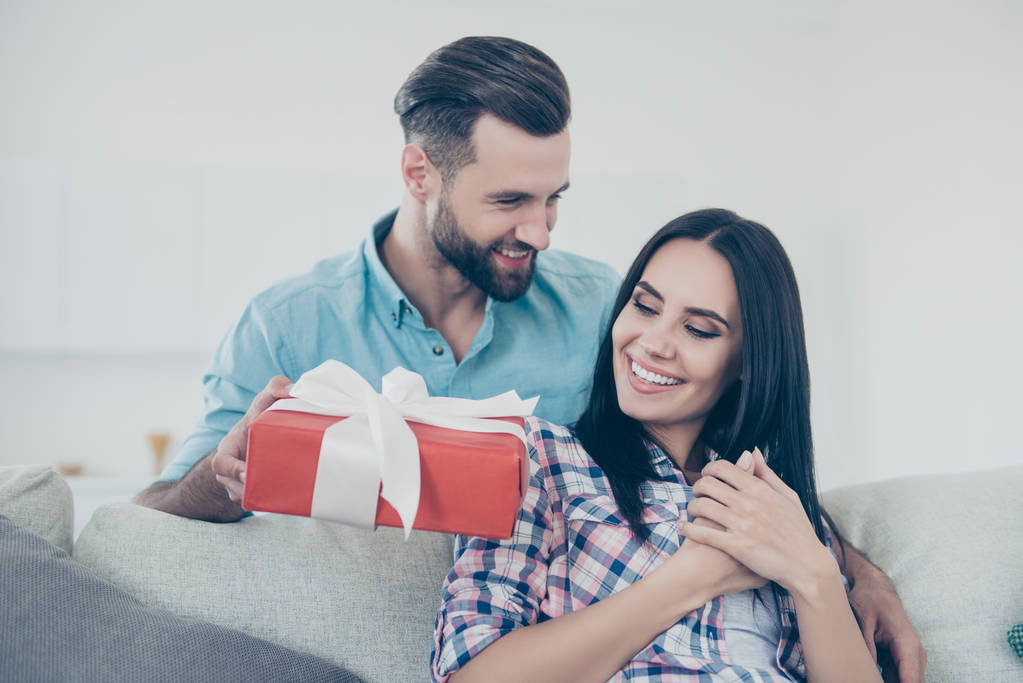 Portrait d'homme élégant donnant boîte cadeau en paquet avec arc à joli amant, couple profitant de l'événement ensemble intérieur
 - Photo, image