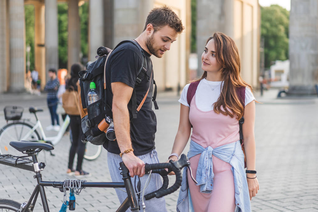 pareja de turistas con mochilas y bicicleta en Pariser Platz en Berlín, Alemania
 - Foto, Imagen