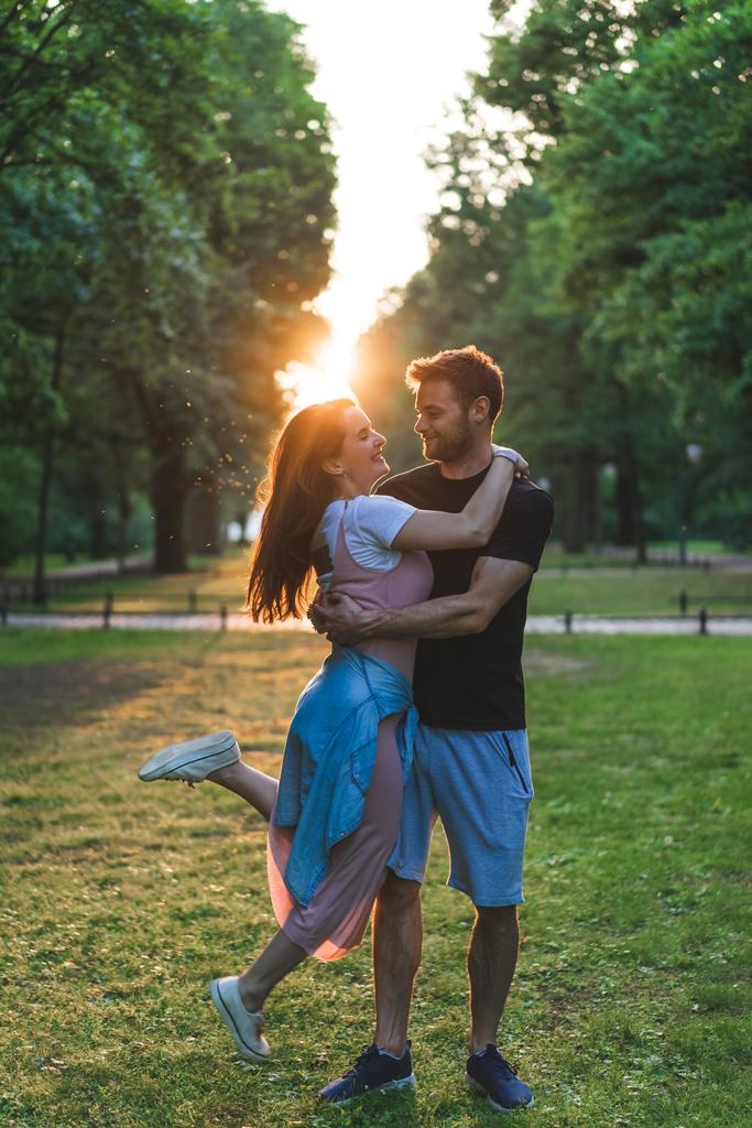 若い男の背後に夕日を公園で目を閉じて保持幸せガール フレンド - 写真・画像