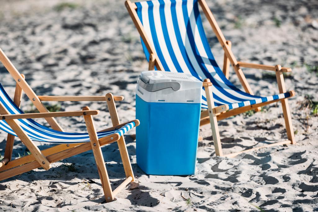 raidallinen ranta tuolit ja jäähdytin hiekalla
  - Valokuva, kuva