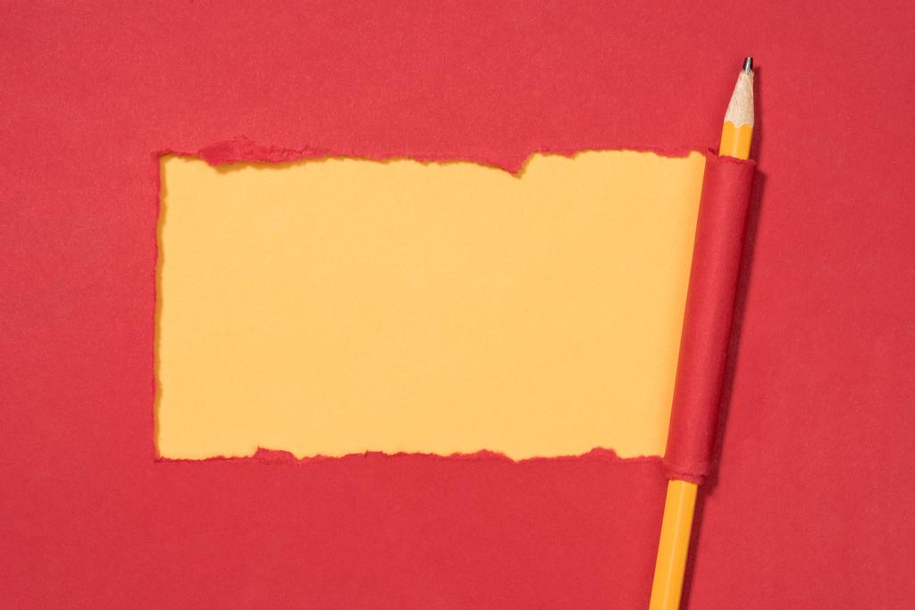 το Top view άρπαξαν κόκκινο χαρτί και μολύβι τυλιγμένο στο κίτρινο  - Φωτογραφία, εικόνα