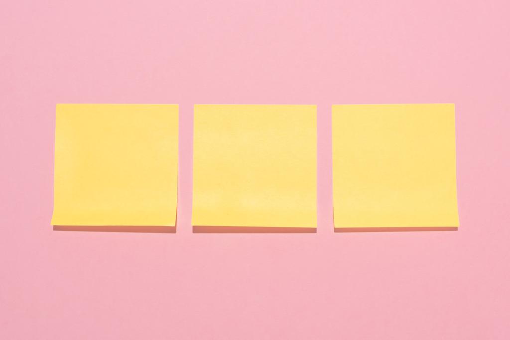 üres sárga botot megjegyzi, rózsaszín sorban elhelyezett felülnézet  - Fotó, kép