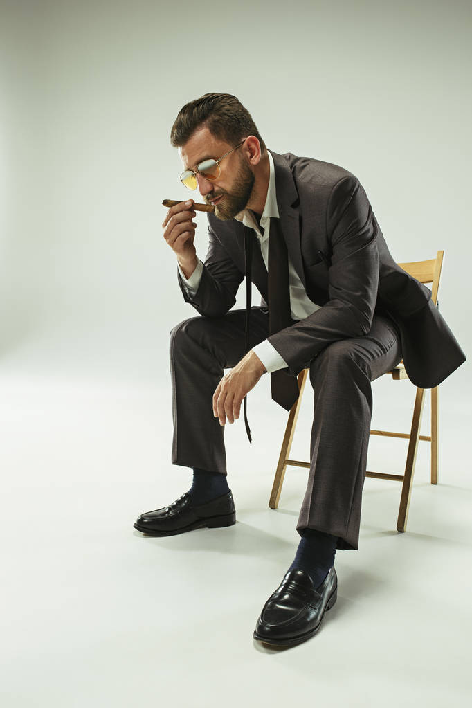 L'uomo bardo in una tuta che tiene il sigaro
 - Foto, immagini