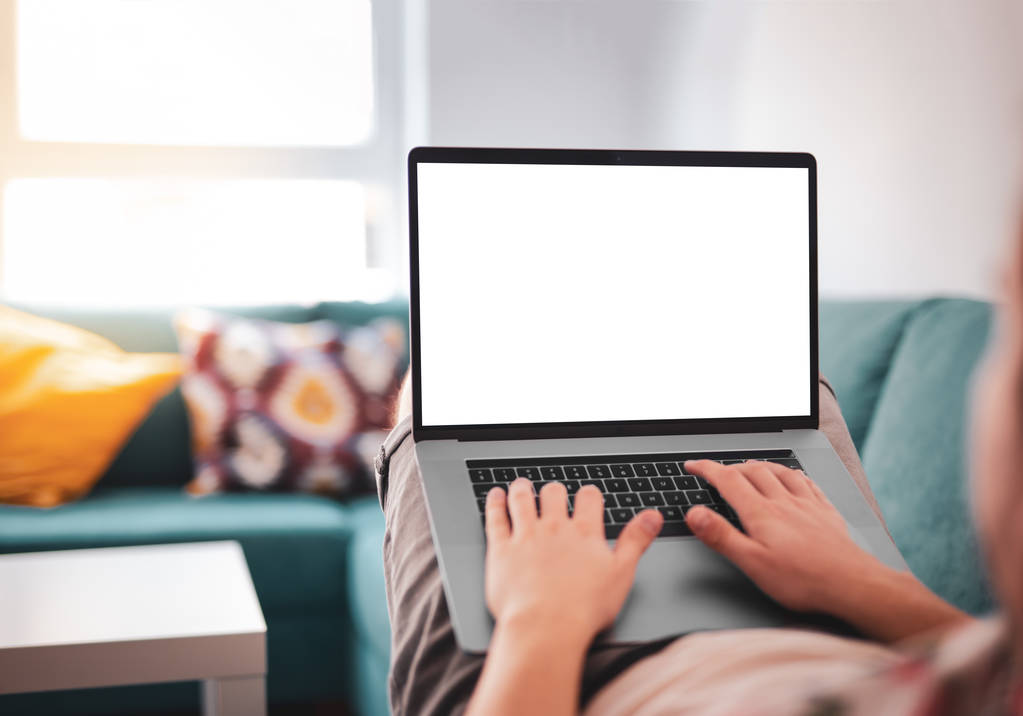 Homem usando, trabalhando em laptop com tela em branco enquanto deitado no sofá na sala de estar. Modelo de modelo de modelo
 - Foto, Imagem