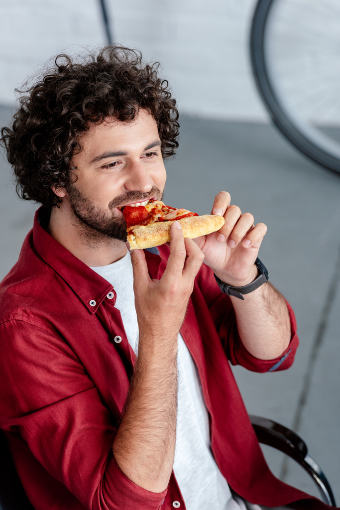 magas, szög, kilátás a fiatalember pizzát ettek és keres el - Fotó, kép