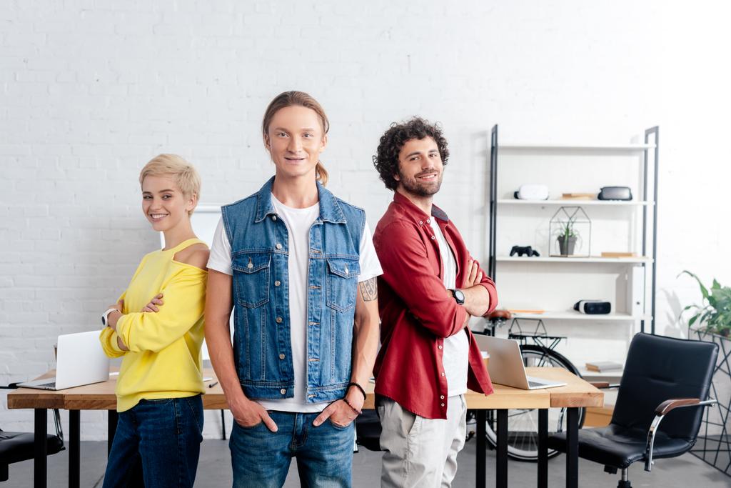 młody biznes drużyna stojąc razem i uśmiecha się do kamery w biurze  - Zdjęcie, obraz