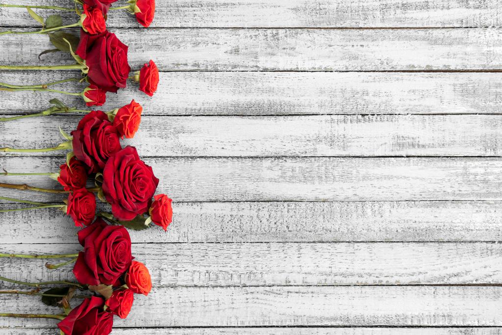 Top view of beautiful red roses on grungy grey wooden table with copy space - Photo, Image